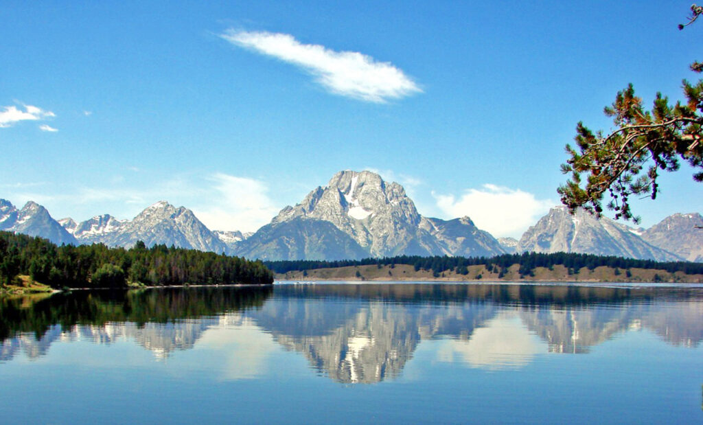 Still lake at dawn reflecting a mountain, an image of the observer and the observed