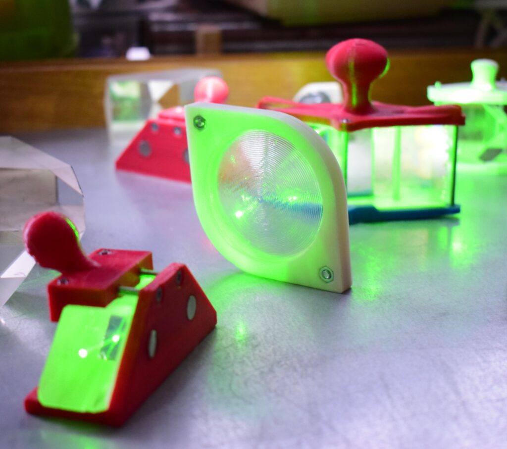 Optical elements and a green laser beam on a lab bench, illustrating the light modes used in quantum teleportation