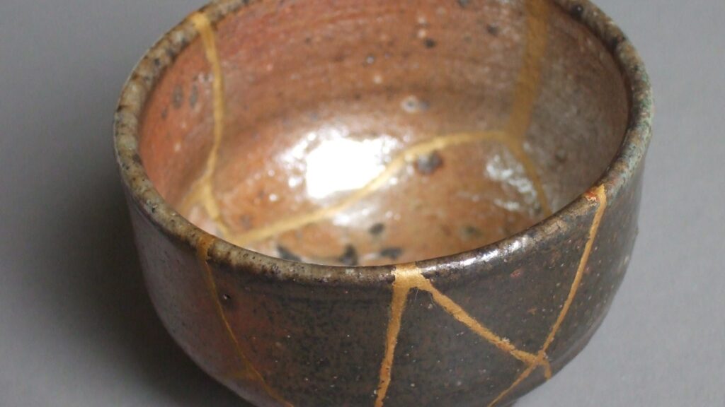 Kintsugi tea bowl whose cracks have been repaired with gold lacquer, a symbol of growth through failure and repair
