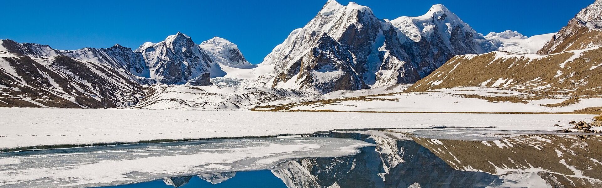 A still lake reflecting mountains, symbolising authenticity as inner coherence in Ad Unum Energy Healing