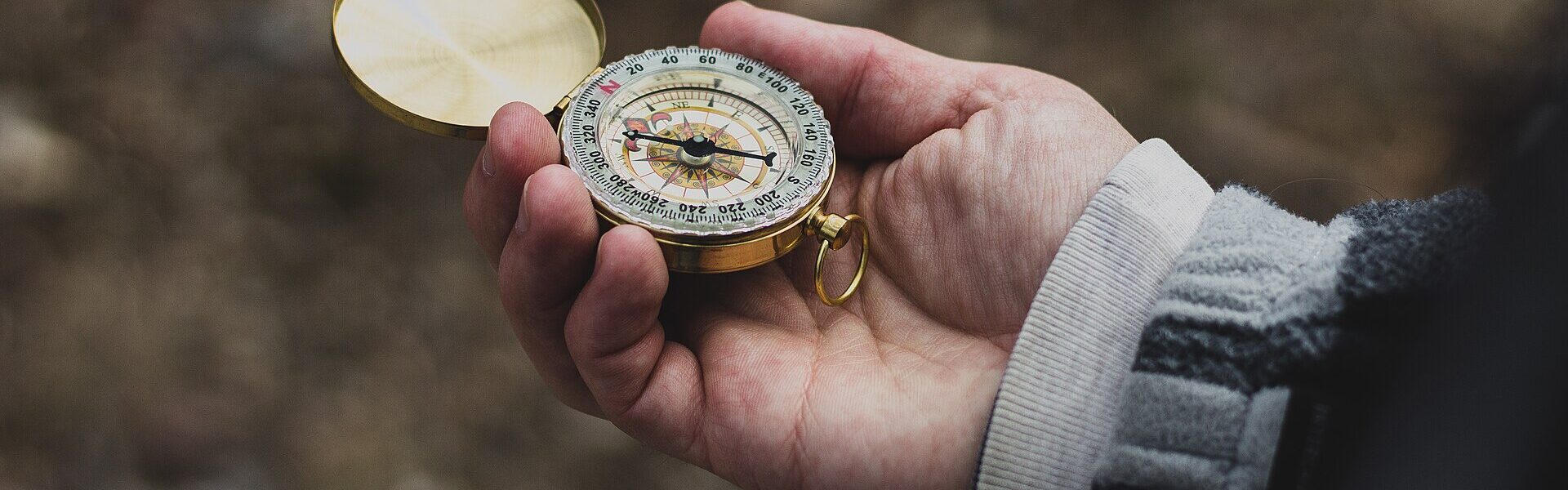 A compass held in hand, symbolising discernment when choosing a serious energy practitioner with Ad Unum