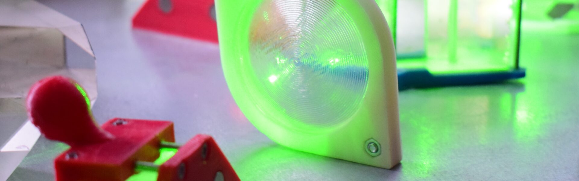 Optical elements and a green laser beam on a lab bench, illustrating the light modes used in quantum teleportation