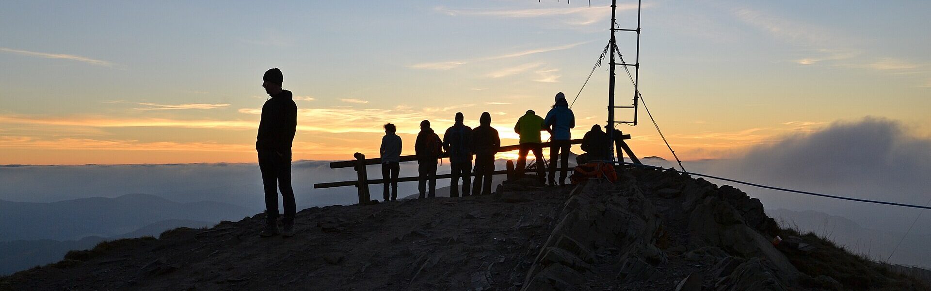A person silhouetted at sunrise on a summit, symbolising rediscovering yourself with Ad Unum Energy Healing
