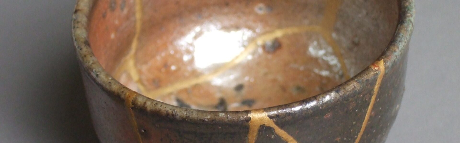 Kintsugi tea bowl whose cracks have been repaired with gold lacquer, a symbol of growth through failure and repair