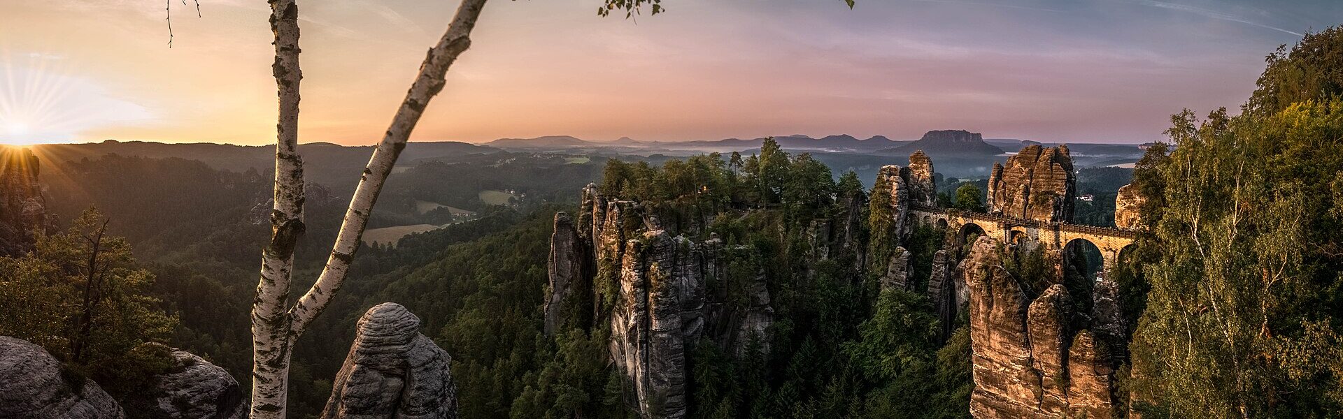 A person with arms outstretched at sunrise, symbolising self-healing as freedom through coherence in Ad Unum Energy Healing